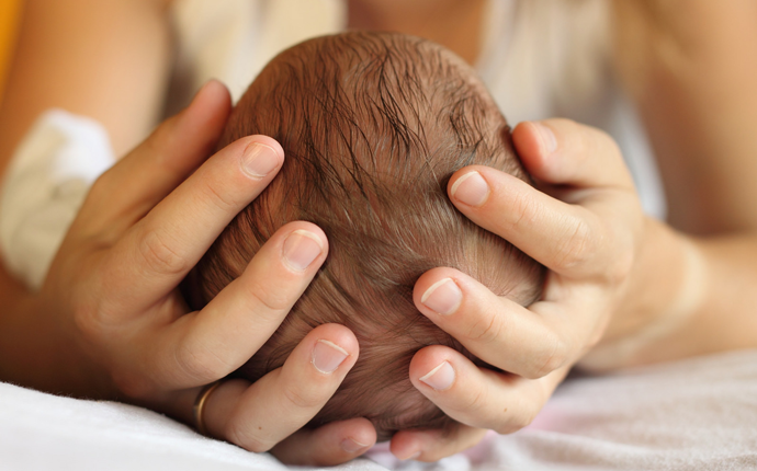 Adult holding baby's head