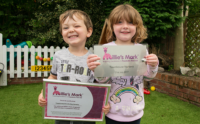 Children at Townhouse Private Day Nursery holding a certificate and plaque