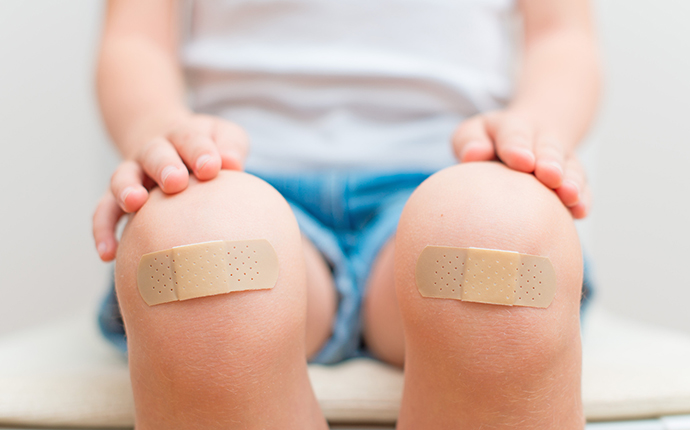 Plasters on child's knees Plasters on child's knees